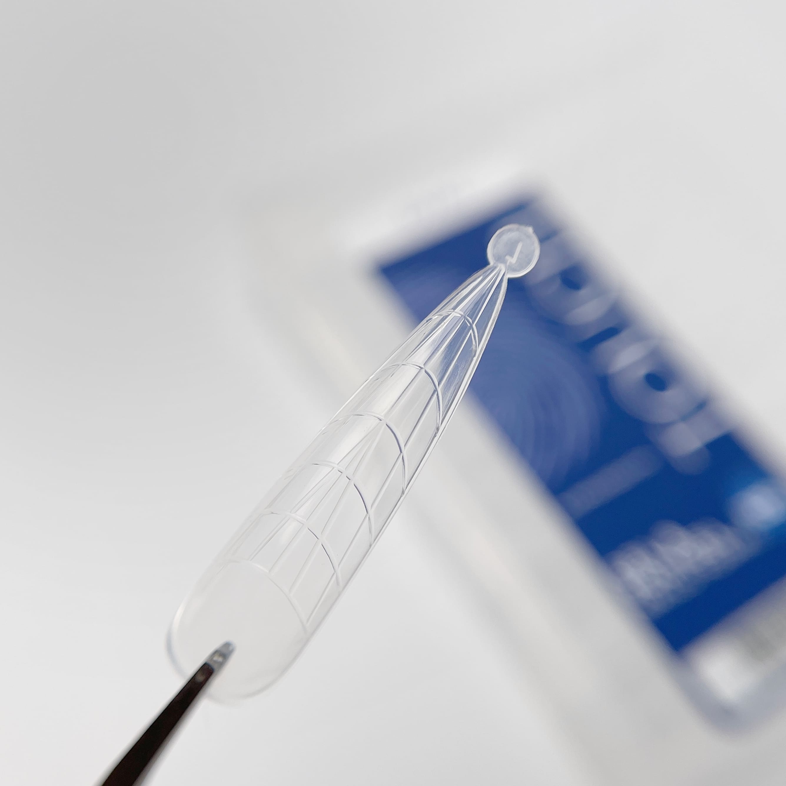 Clear plastic tool with a blue blurred background