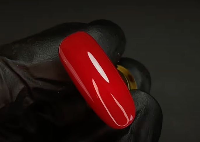 Dark red gel polish color of Kinetics brand on white background