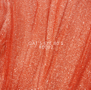 Close-up of a glittery lip color swatch labeled 'Cat's Eye 80's #0002'.