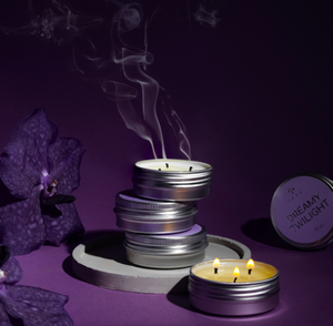 Stack of metal candle holders with smoking candles on a purple background