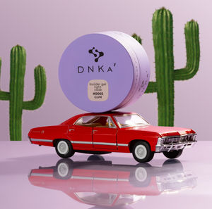 DNKa hair product container on a red car with cacti in the background