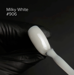White nail polish brush with a milky white color swatch labeled #906 on a dark background.