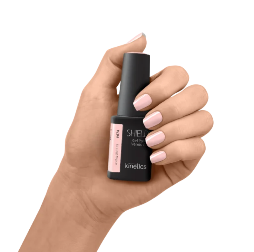Hand holding a black nail polish bottle labeled 'kinetics' on a white background