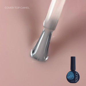 Nail art brush with a bottle of nail polish labeled 'Touch' on a pink background
