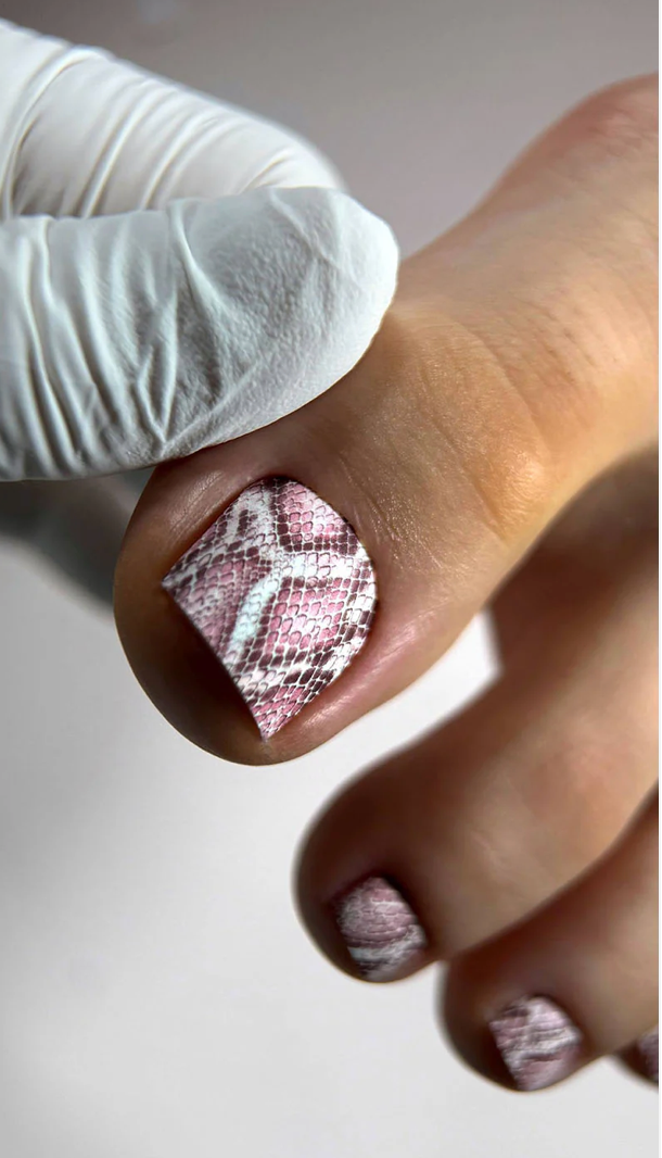 Close-up of a hand with textured nail polish wearing a white glove.