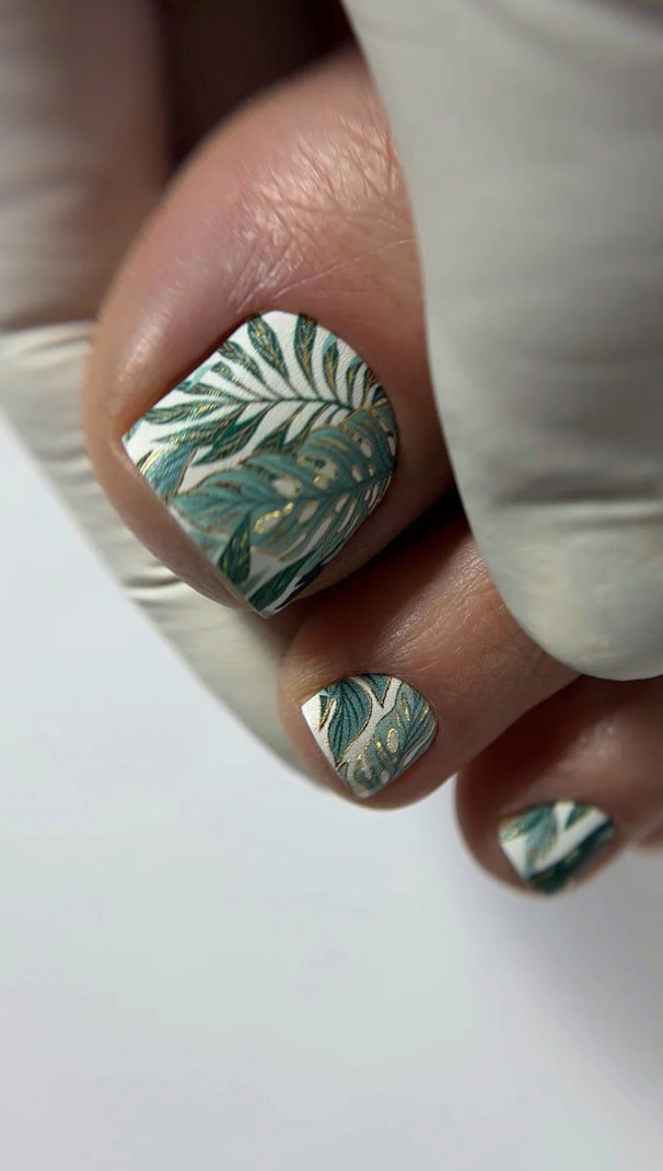 Nail art with leaf design on a white background