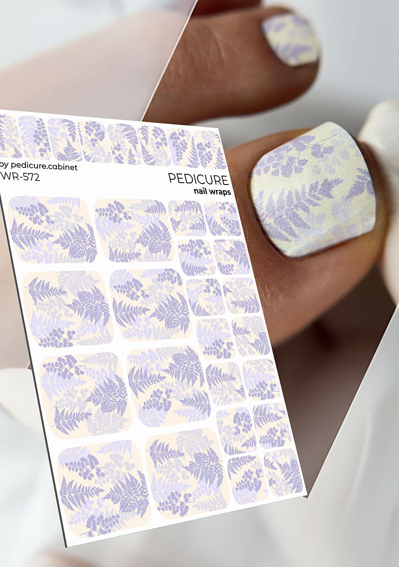 Nail wrap packaging with floral design and a hand wearing a nail wrap.