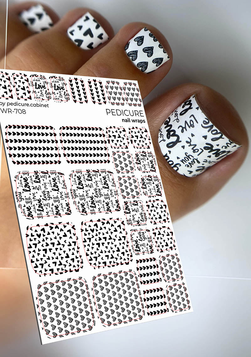 Nail wrap sheet with black and white designs held by a hand with similarly styled nails.