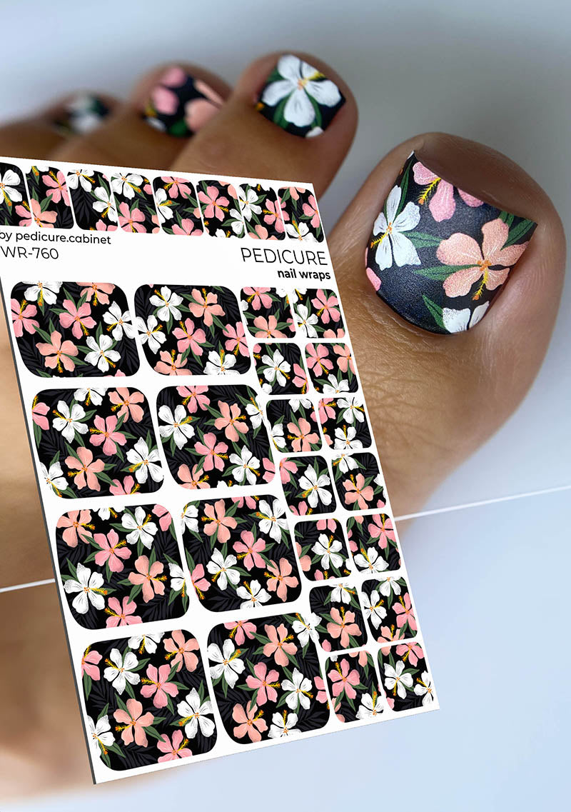 Floral pedicure nail wraps on a hand with a white background