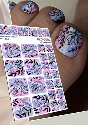 Nail art foil wraps with floral designs held by a hand with painted nails.
