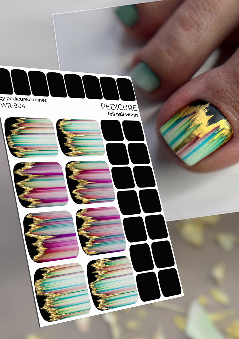 Foil nail wraps with colorful nail art design and a hand with painted nails.