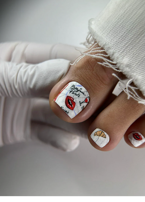 Close-up of a hand with creatively designed nails featuring artistic elements.