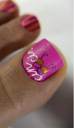 Nail art with a pink accent nail featuring a wine glass design and 'Wine Me' text.