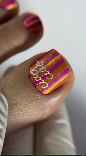 Nail with colorful design and 'Happy' text on a white background
