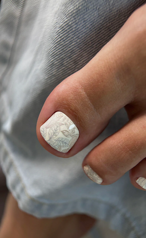 Close-up of a hand with textured nail polish on a blurred background