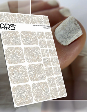 Nail art foil sheet with floral design held by a hand with a manicured nail.