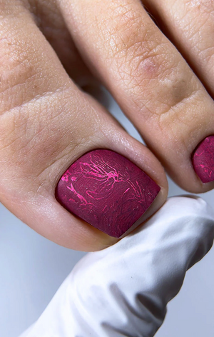 Close-up of a hand with pink nail polish on a light background