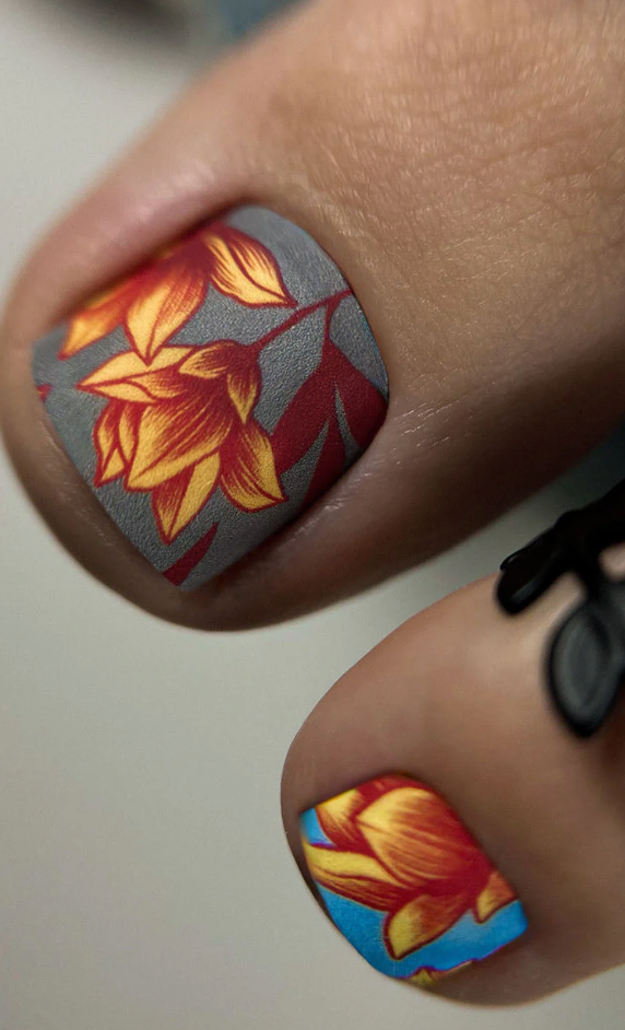 Close-up of a person's nails with floral nail art on a neutral background