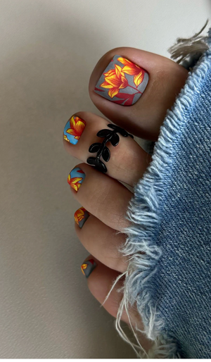 Close-up of toes with colorful nail art on a neutral background