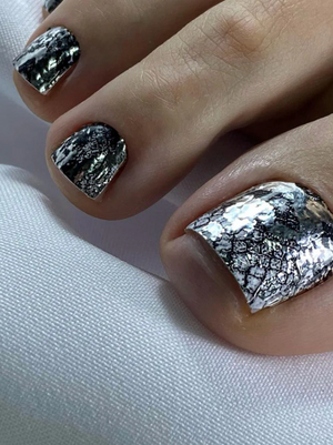 Close-up of a hand with silver and black marbled nail polish on a white background
