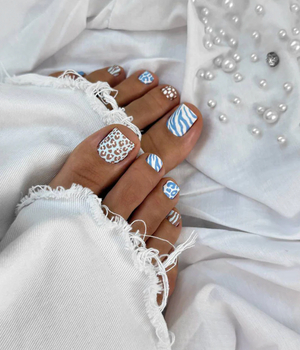 Nails with blue and white patterns on a white fabric background