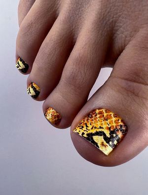 Hand with tortoiseshell nail design on a light gray background