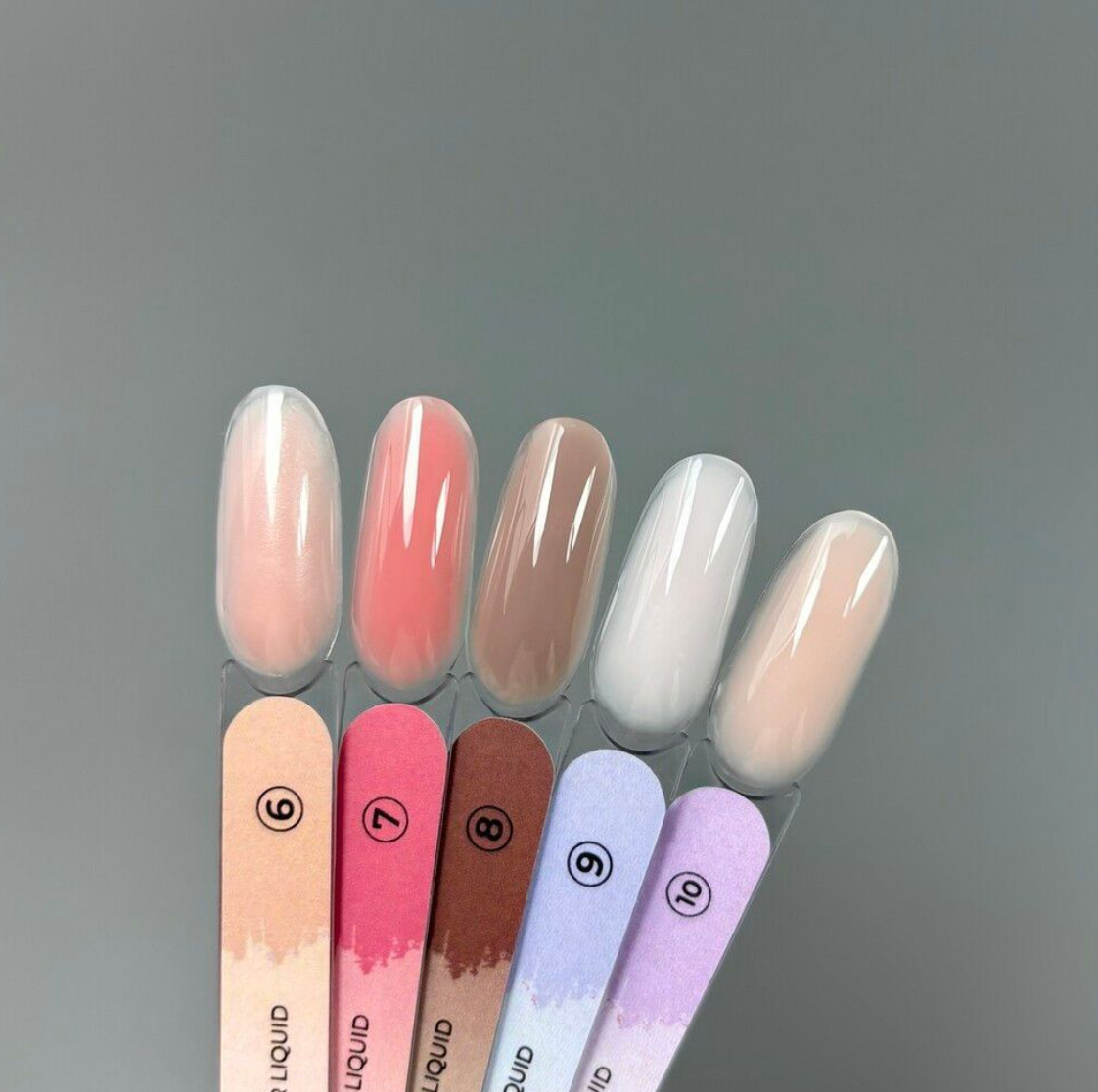 Set of gradient nail polishes on a gray background