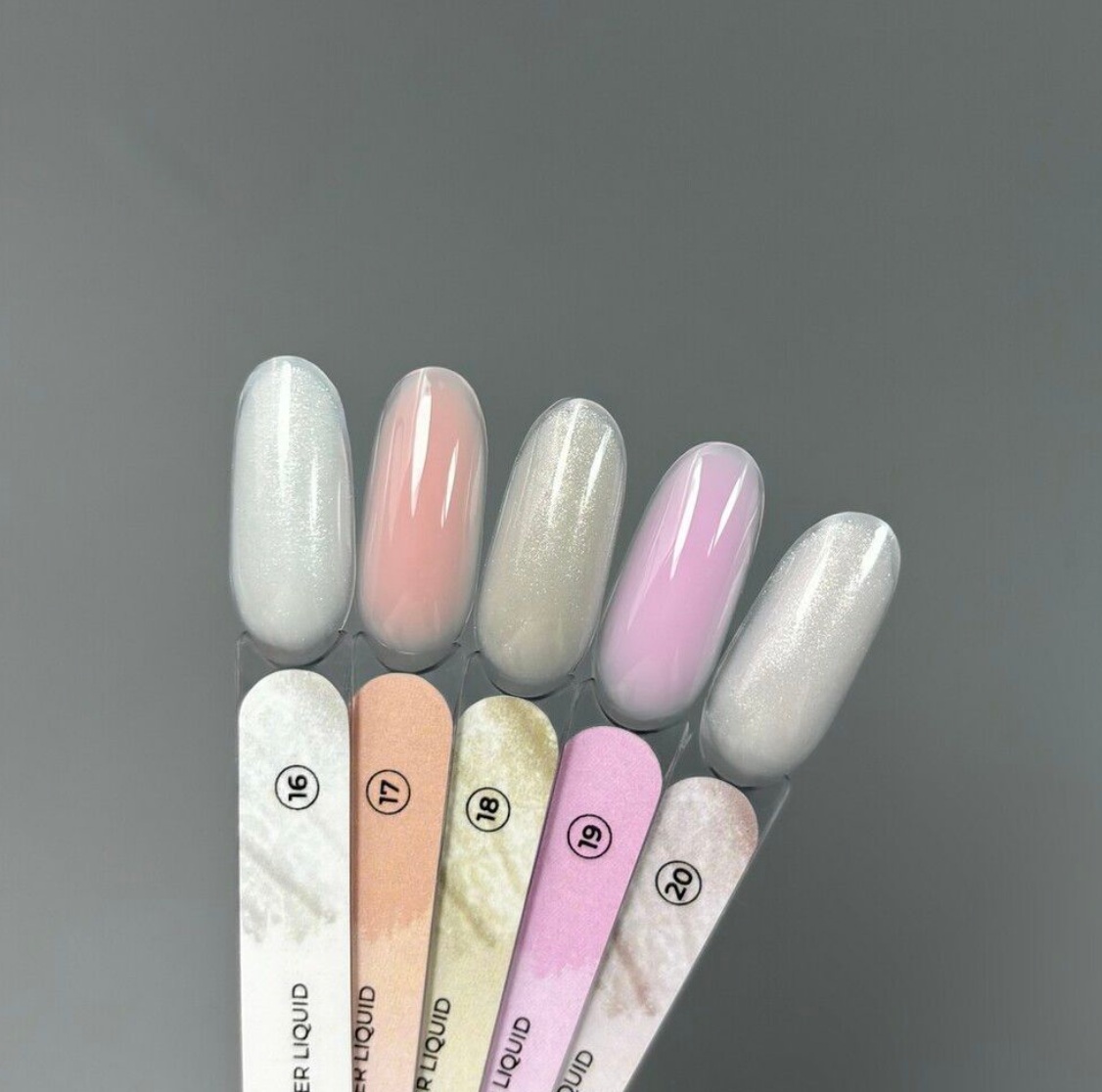 Set of nail polish swatches with a gradient of colors on a gray background