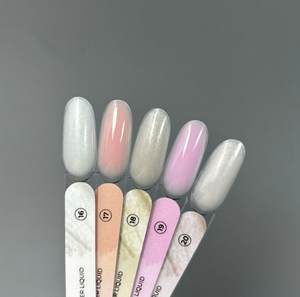 Set of nail polish swatches with a gradient of colors on a gray background