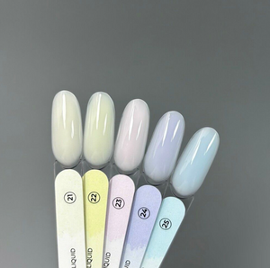 Set of nail polish tubes with pastel colors on a gray background