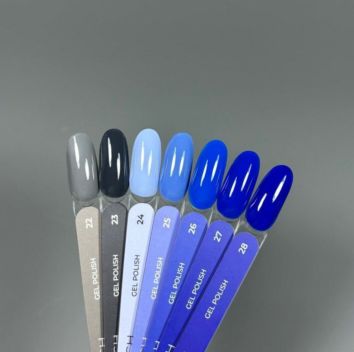 Set of gel polish samples with gradient colors on a gray background
