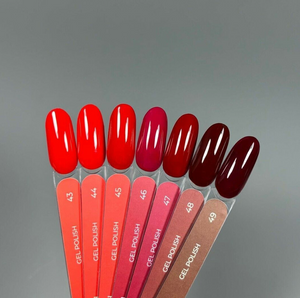 Nail polish color swatch with red and brown shades on a gray background