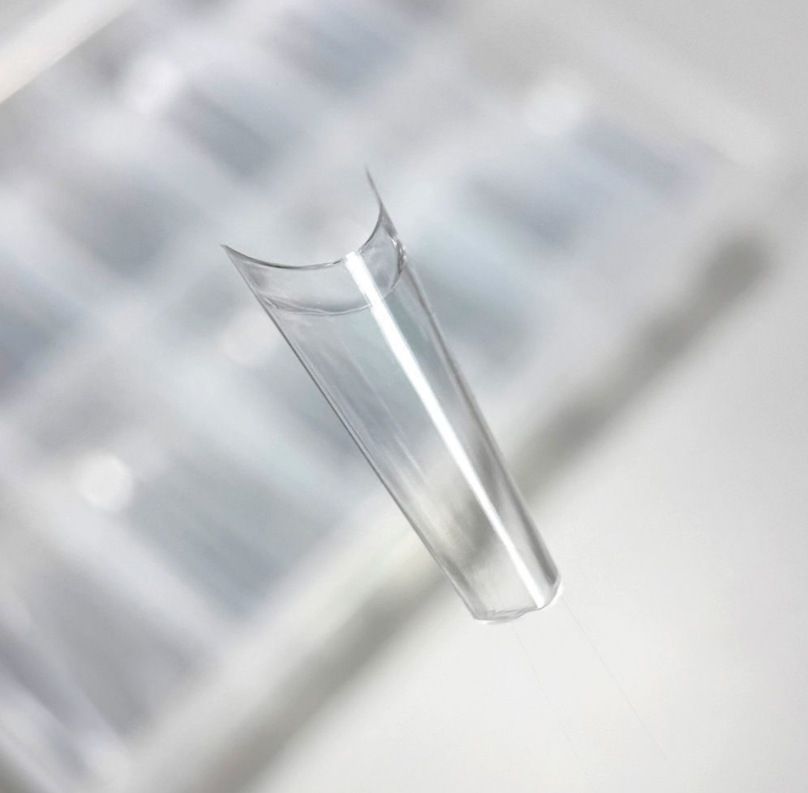 Clear glass vase on a reflective surface with geometric patterns
